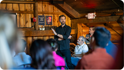 A man standing in the front of a room presenting