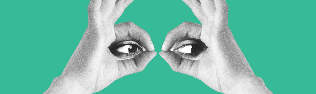 Hands held in the shape to make an eye on a blue background